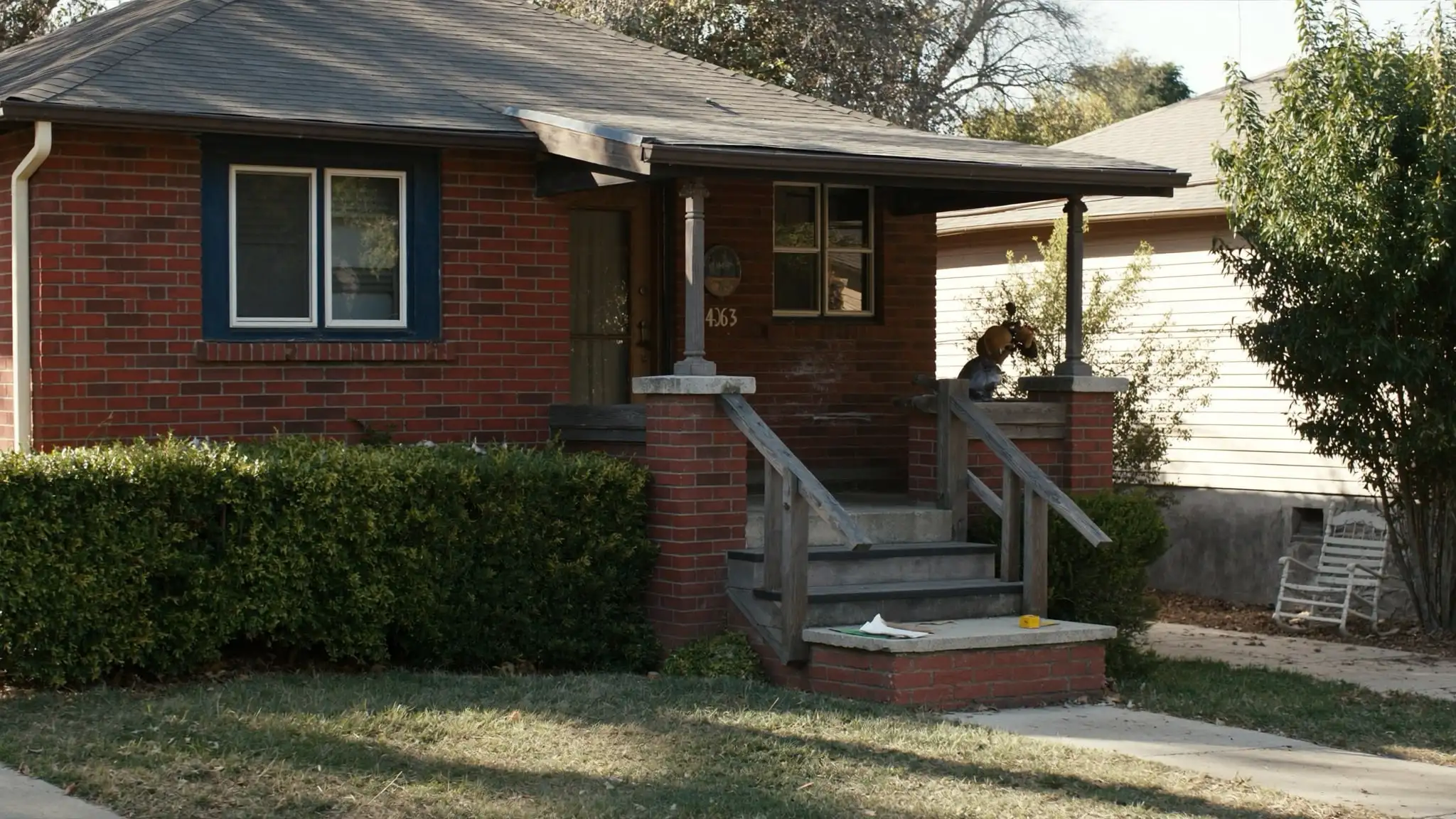Brick bungalow with a clipboard and tape measure on the porch steps