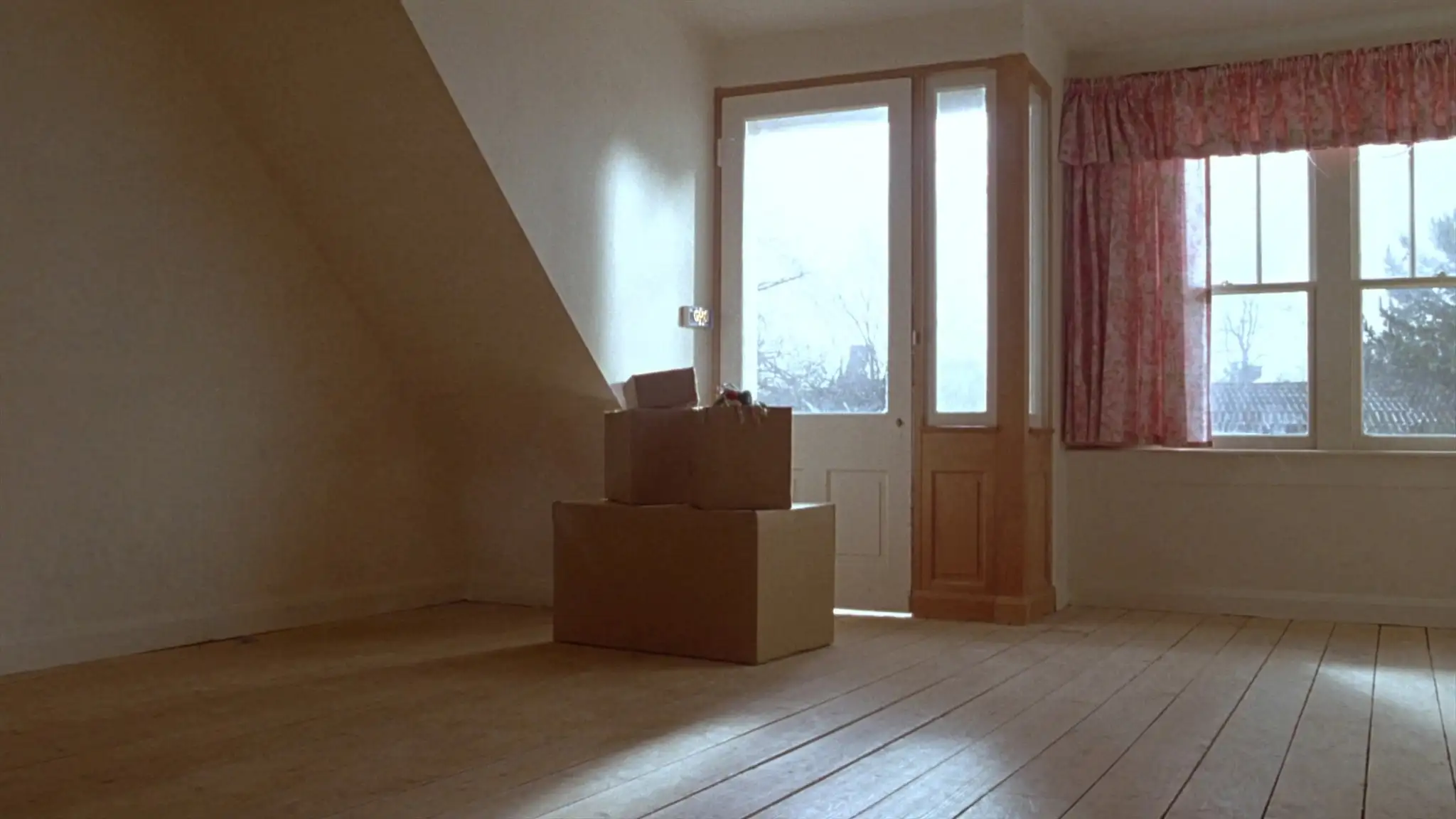 Moving boxes in an empty living room near the front door