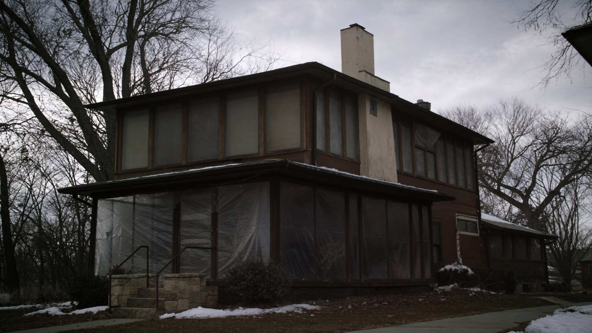 Vacant two-story house in winter with snow in the yard